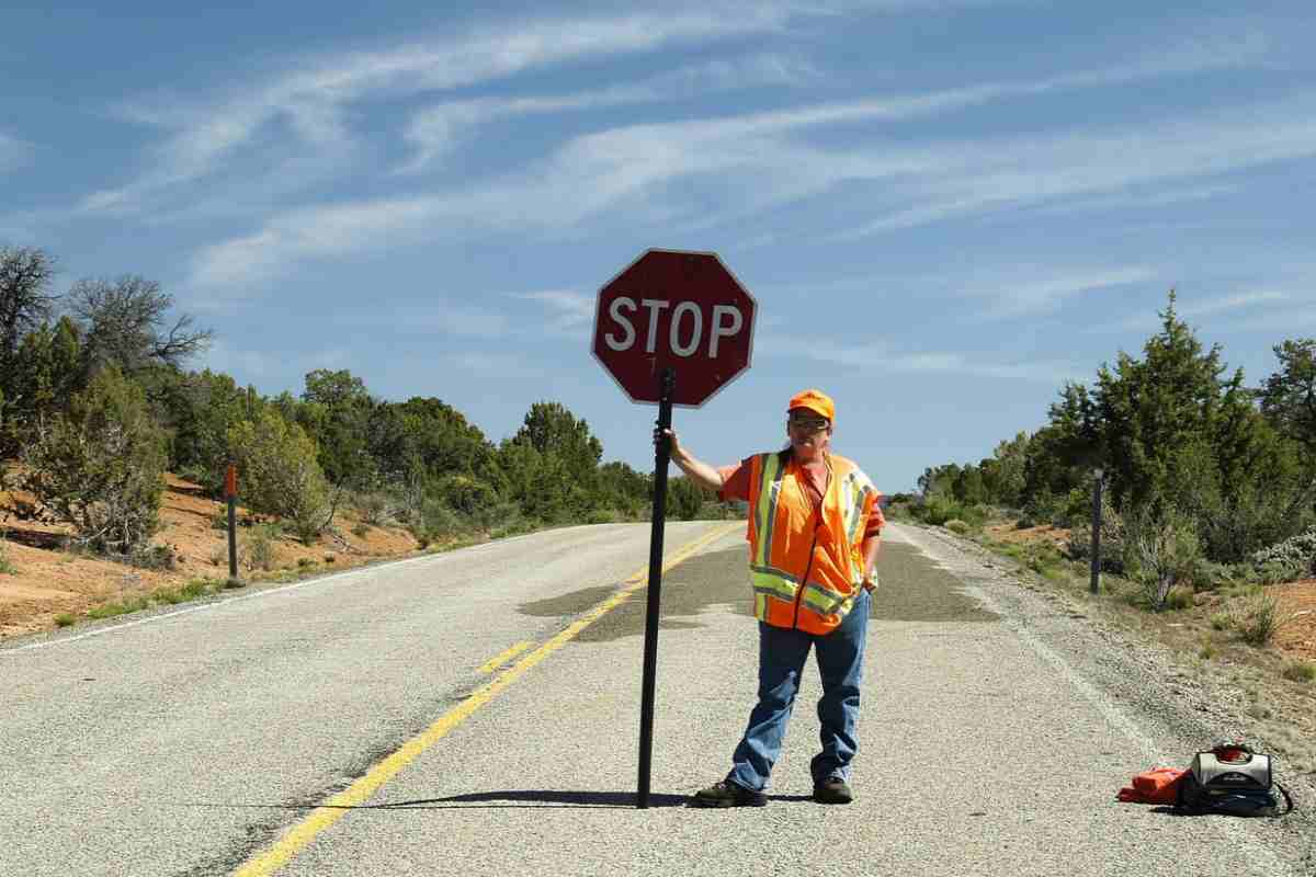 Operaio con cartello di STOP in mano