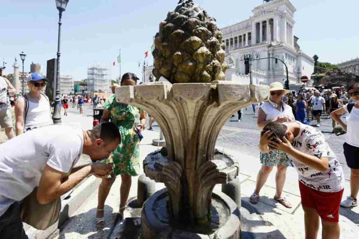 Persone che si rinfrescano sotto la fontana