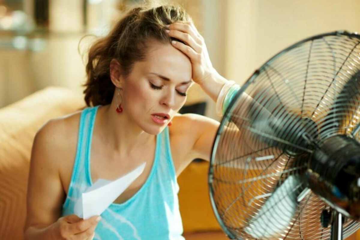 Donna che cerca di rinfrescarsi davanti al ventilatore