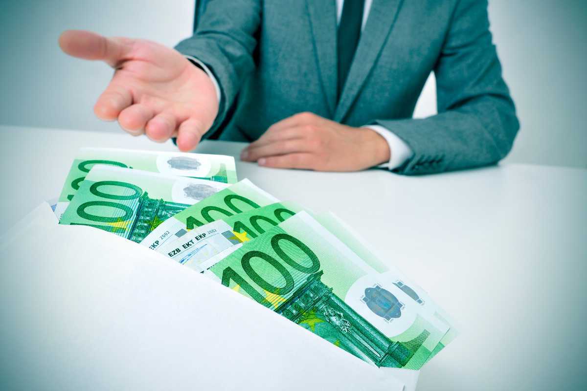 Persona seduta, busta con banconote