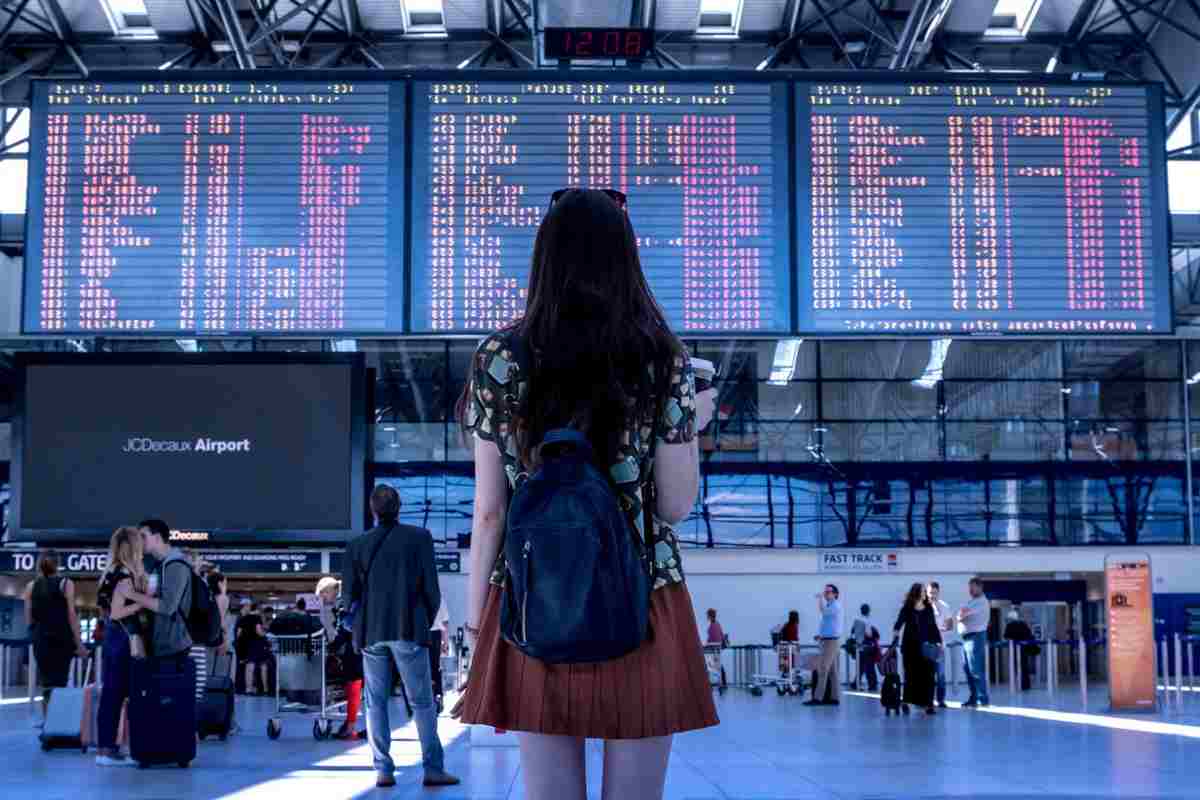 Ragazza in aeroporto davanti a un tabellone